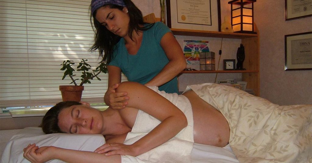 Dana Scarano giving a prenatal massage in a client's home