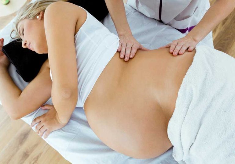 Full term pregnant woman receiving an induction massage.